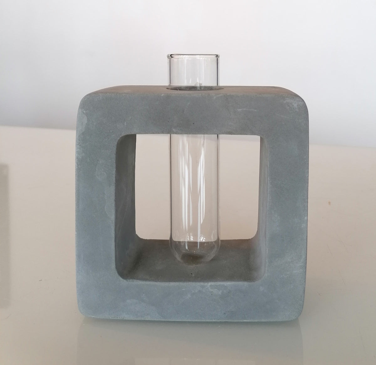 Betoncubus mit Vase für eine Blume